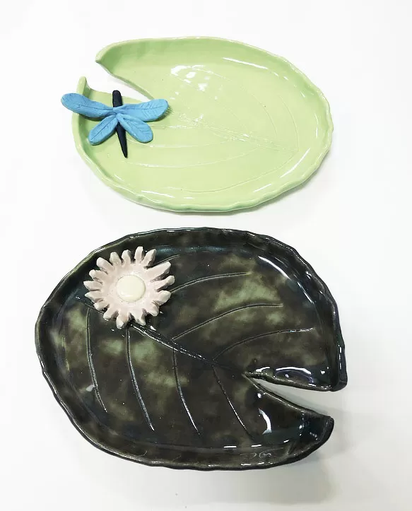  Two ceramic plates featuring a dragonfly and a leaf design